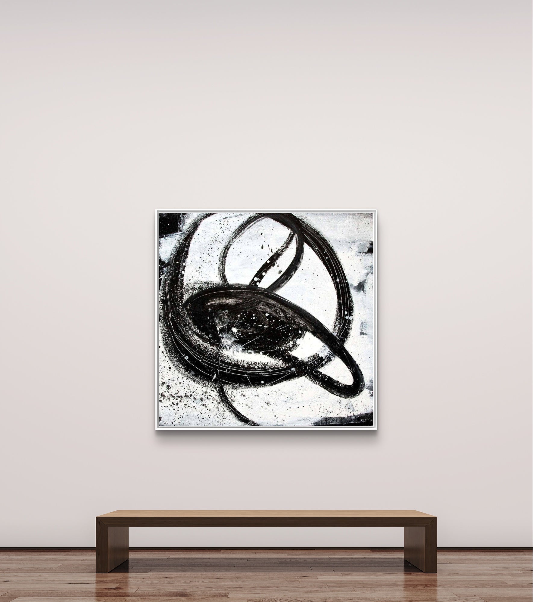 In einer minimalistischen Galerie hängt "Nightswimming" von Conny Wachsmann über einer schlichten Holzbank - ein quadratisches, abstraktes Schwarz-Weiß-Gemälde mit kühnen, wirbelnden Ringen und Spritzern auf einem strukturierten weißen Hintergrund.