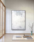 Minimalistischer Raum mit Tatami-Matten, Bodenkissen und einem niedrigen Tisch mit einem Teeservice. An der Wand hängt "Stiller Spaziergang" von Conny Wachsmann, Künstlerin - seine sanften Farbtöne sorgen für Ruhe und Entspannung, wenn das Sonnenlicht durch die Holzgitterfenster fällt.