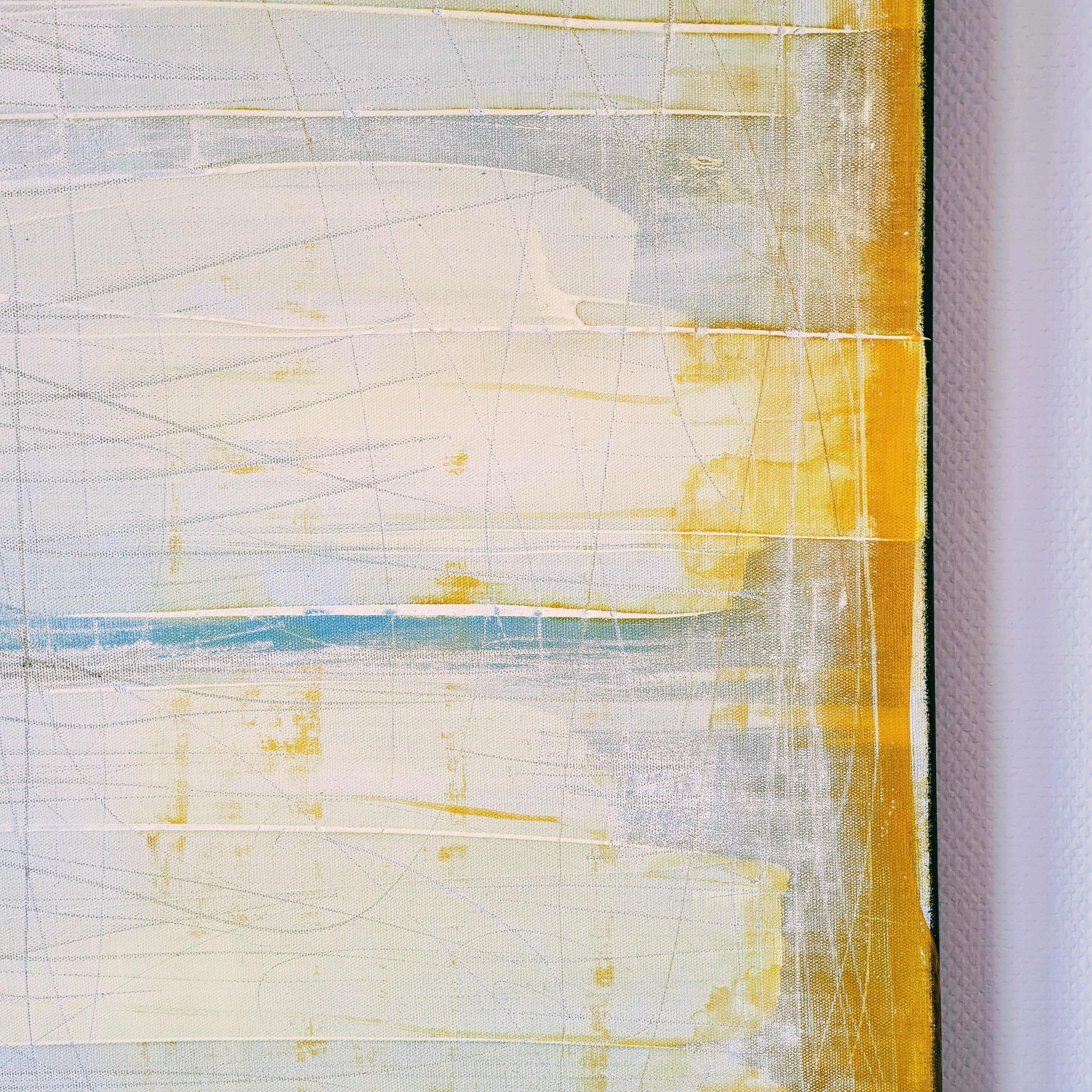 Küstenzauber II von Conny Wachsmann ist in Gelb-, Weiß- und Hellblautönen gehalten und erinnert an eine abstrakte Landschaft. Dünne, sich kreuzende Linien verleihen breiten Flächen Struktur, wobei die Leinwandkante rechts einen Teil der Wand freigibt.