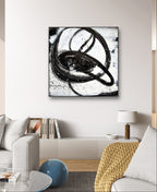 Ein modernes Wohnzimmer mit einem weißen Sofa, einer beigen Strickdecke, einem runden blauen Hocker und einem weißen Schrank. Über dem Schrank hängt "Nightswimming" von Conny Wachsmann, Künstlerin - ein markantes abstraktes Gemälde mit wirbelnden Pinselstrichen.