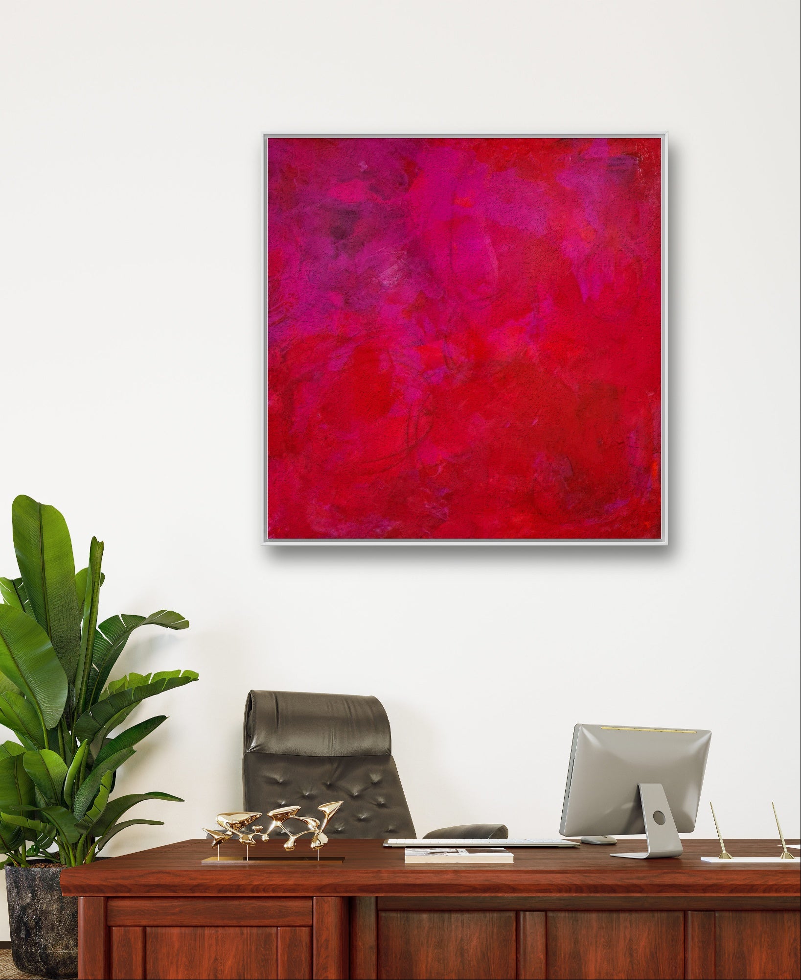 Ein modernes Büro mit Holzschreibtisch, Computer und Stuhl. Über dem Schreibtisch hängt das Bilderset „Stärke“ von Conny Wachsmann, dessen leuchtende Rottöne für eine individuelle Note sorgen. Eine Grünpflanze bringt Frische in den Raum.