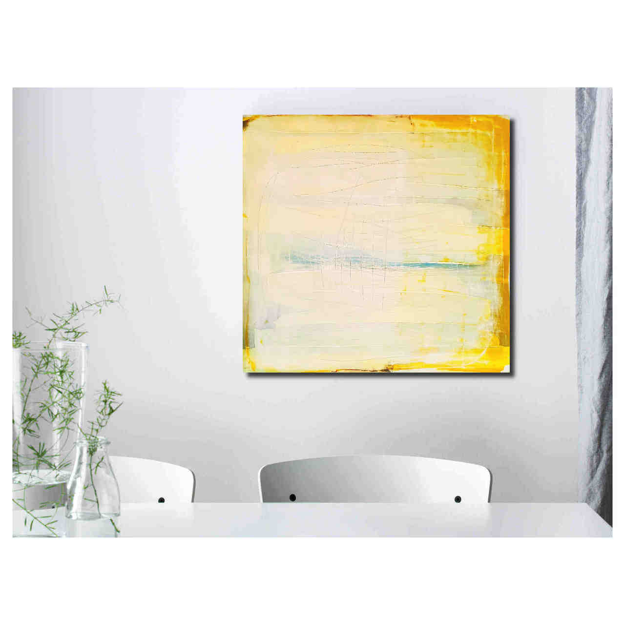 Minimalistischer Essbereich mit zwei weißen Stühlen, einem weißen Tisch, zwei Glasvasen mit grünen Stielen und „Küstenzauber II“ von Conny Wachsmann an der Wand.