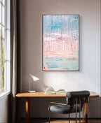 Ein minimalistischer Arbeitsbereich mit einem Holzschreibtisch, einem offenen Buch, einer modernen Lampe, einem schwarzen Stuhl und "Vorschiedene Weiten" von Conny Wachsmann an der hellgrauen Wand. Natürliches Licht strömt durch ein Fenster herein.