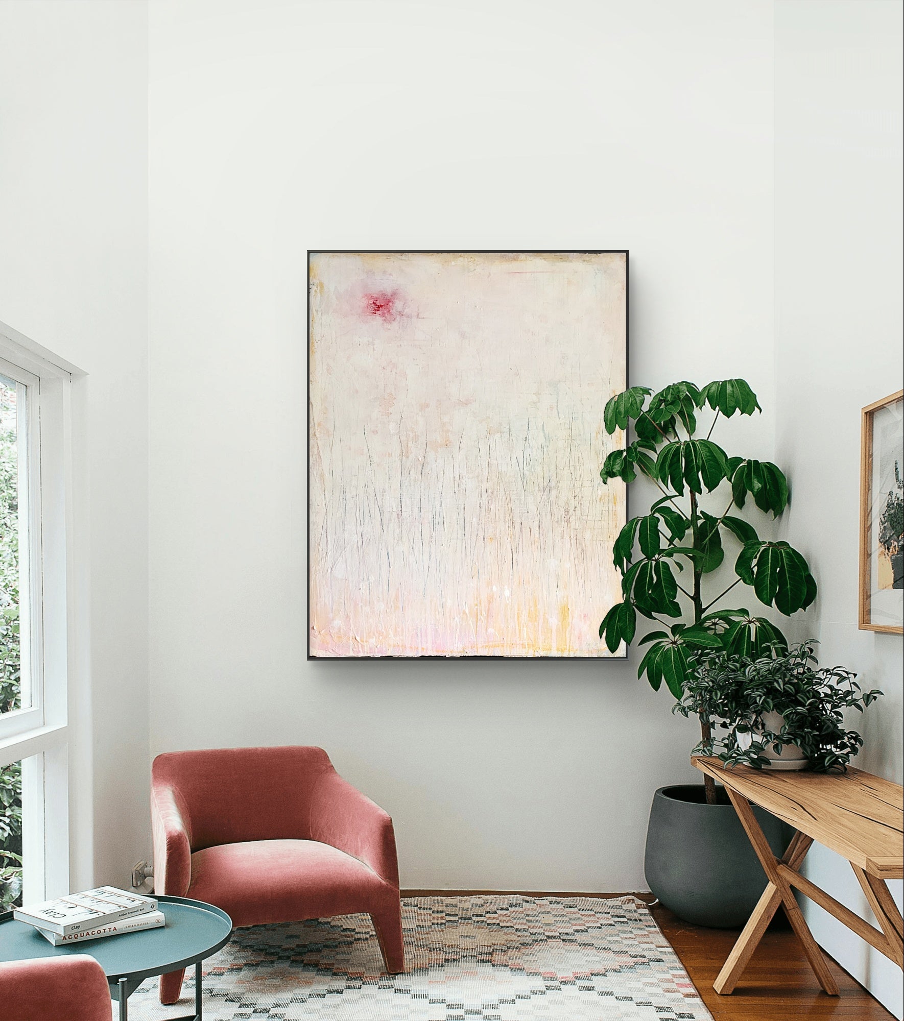 Ein modernes, minimalistisches Wohnzimmer mit „Gedankenregen“ von Conny Wachsmann als Mittelpunkt, zwei rosa Sesseln, einem runden grünen Tisch, einer grünen Topfpflanze, einem Konsolentisch und einfallendem Tageslicht.