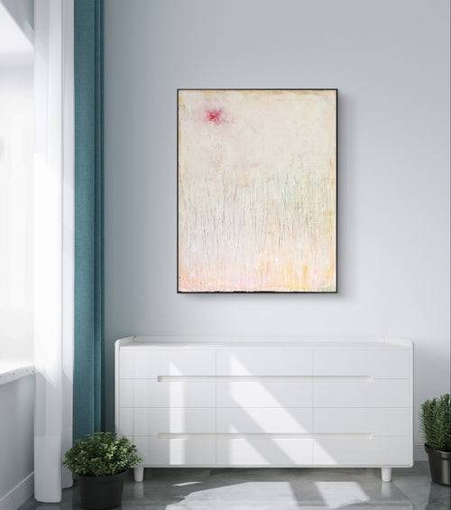 Ein minimalistisch-moderner Raum mit einer weißen Kommode, Topfpflanzen und „Gedankenregen“, einem maßgeschneiderten Unikat der Künstlerin Conny Wachsmann – einem abstrakten Pastellkunstwerk mit einem rosa Fleck – das an einer hellgrauen Wand hängt.