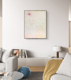 Ein modernes Wohnzimmer mit einem hellgrauen Sofa, einem blauen Ottomanen und einer senfgelben Decke – perfekt, um „Gedankenregen“ von Conny Wachsmann, Künstlerin, über der eleganten weißen Medienkonsole zu präsentieren und so eine künstlerische Note zu verleihen.