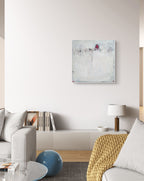 Modernes Wohnzimmer mit hellem Sofa, strukturierter Decke und rundem blauem Dekor. Über dem Schrank an der weißen Wand hängt „Stille Spur“, ein abstraktes Originalgemälde in Weiß und Rot der Künstlerin Conny Wachsmann.