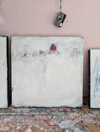 „Stille Spur“ von Conny Wachsmann: Ein minimalistisches Originalgemälde mit weißem Hintergrund, feinen Linien und einem kleinen roten Haus. Vintage-Kamera und rosafarbener Wand, Farbspritzer bedecken die Fläche darunter.