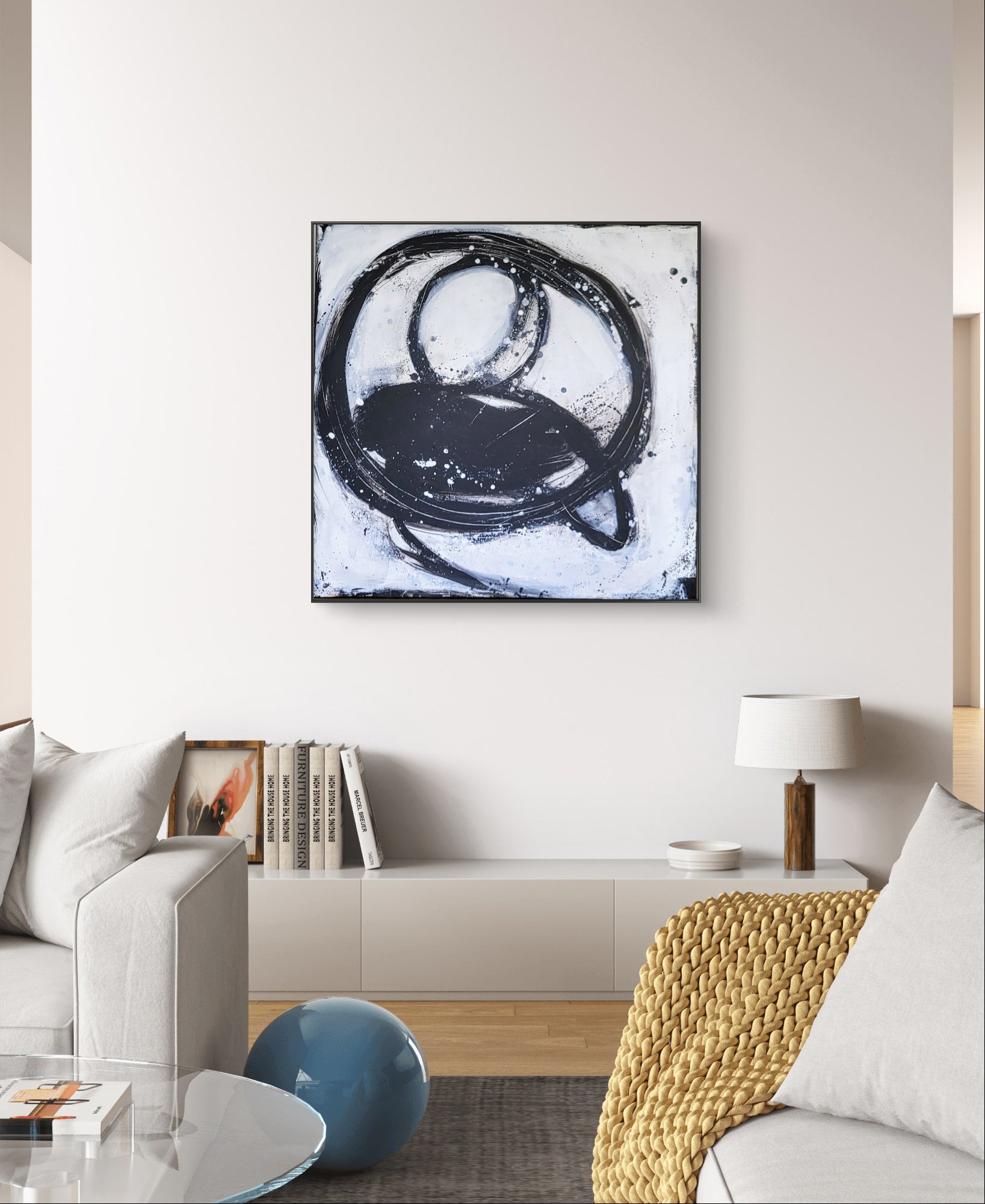 Ein modernes Wohnzimmer mit einem grauen Sofa, einer strukturierten gelben Decke, Büchern auf einem niedrigen weißen Schrank und "Nightswimming" von Conny Wachsmann verleiht ihm einen einladenden und zugleich künstlerischen Touch.