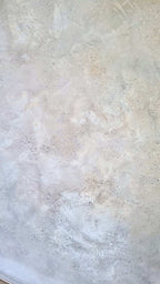 Eine Nahaufnahme von „Spurensuche“ der Künstlerin Conny Wachsmann zeigt die strukturierte, cremefarbene Oberfläche mit hellgrauen, beigen und schwachen Brauntönen, subtilen Sprenkeln und unregelmäßigen Mustern aus Beton-Leichtmasse.