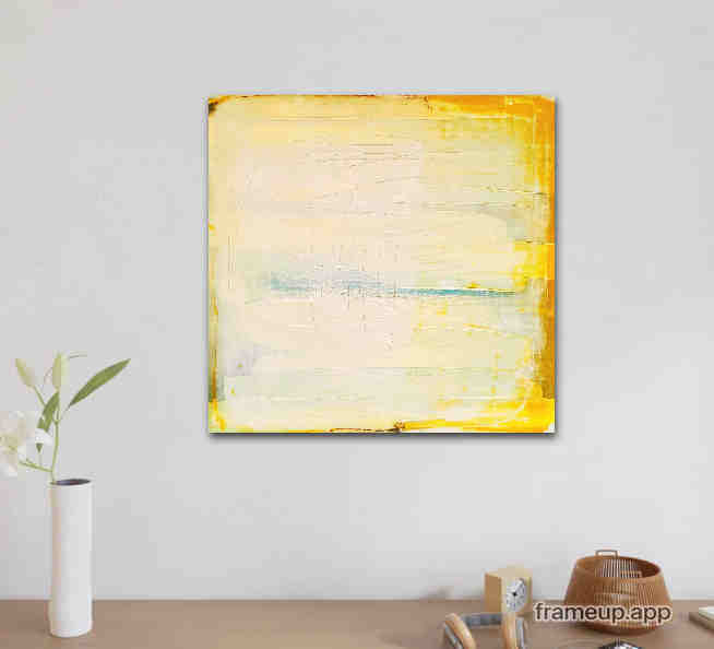 Ein minimalistischer Raum präsentiert „Küstenzauber II“ von Conny Wachsmann, Künstlerin – eine quadratische abstrakte Landschaft in Gelb und Creme – an einer weißen Wand. Darunter steht eine weiße Vase mit grünen Blättern und kleinen Objekten auf einem Leuchttisch.