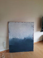 Ein Ausweg", eine quadratische Leinwand von Conny Wachsmann, zeigt einen abstrakten Paynesgrau-Farbverlauf, der unten von Dunkelblau zu Hellgrau übergeht. Es lehnt an einer beigen Wand über einem Holzfußboden, wobei links eine Steckdose und ein Kabel zu sehen sind.