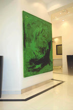 Das große abstrakte Gemälde "Schmetterling" der Künstlerin Conny Wachsmann in den Farben Grün und Schwarz hängt an einer weißen Wand in einem modernen minimalistischen Raum mit weißem Hochglanzboden und Einbaubeleuchtung.