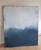 Ein Ausweg" von Conny Wachsmann, Künstlerin: Ein großes abstraktes Werk ruht auf einem Holzboden, wobei das Paynesgrau am Boden durch strukturierte Pinselstriche nach oben in Hellgrau und Weiß übergeht.