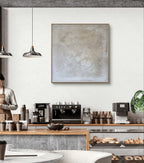 Modernes Café-Interieur mit neutralem Dekor, Kaffeemaschinen und Gebäck. An der weißen Wand hängt „Spurensuche“ von Conny Wachsmann, Künstlerin, in einem Schattenfugenrahmen.