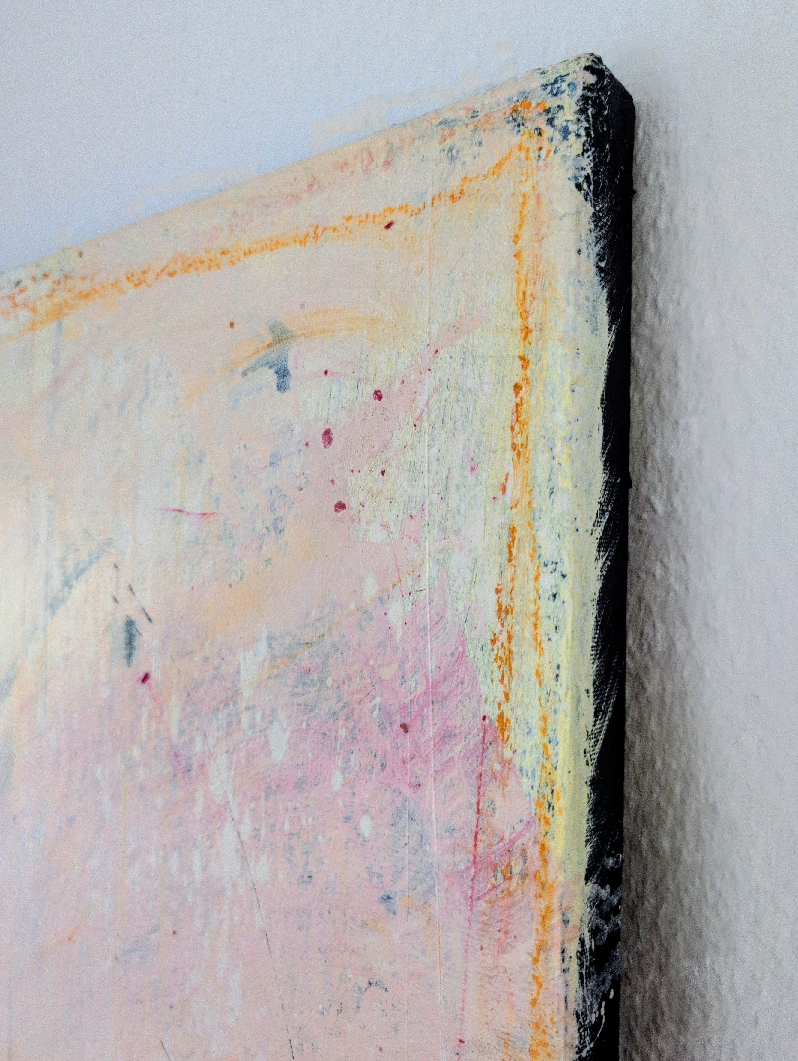 Eine Nahaufnahme von Eichhörnchentanz von Conny Wachsmann zeigt strukturierte Pinselstriche in zartem Rosa, Weiß, Orange und Gelb mit Spritzern und Kratzern. Die schwarz umrandete Leinwand bildet eine auffällige Wanddekoration auf einer weißen Wand.