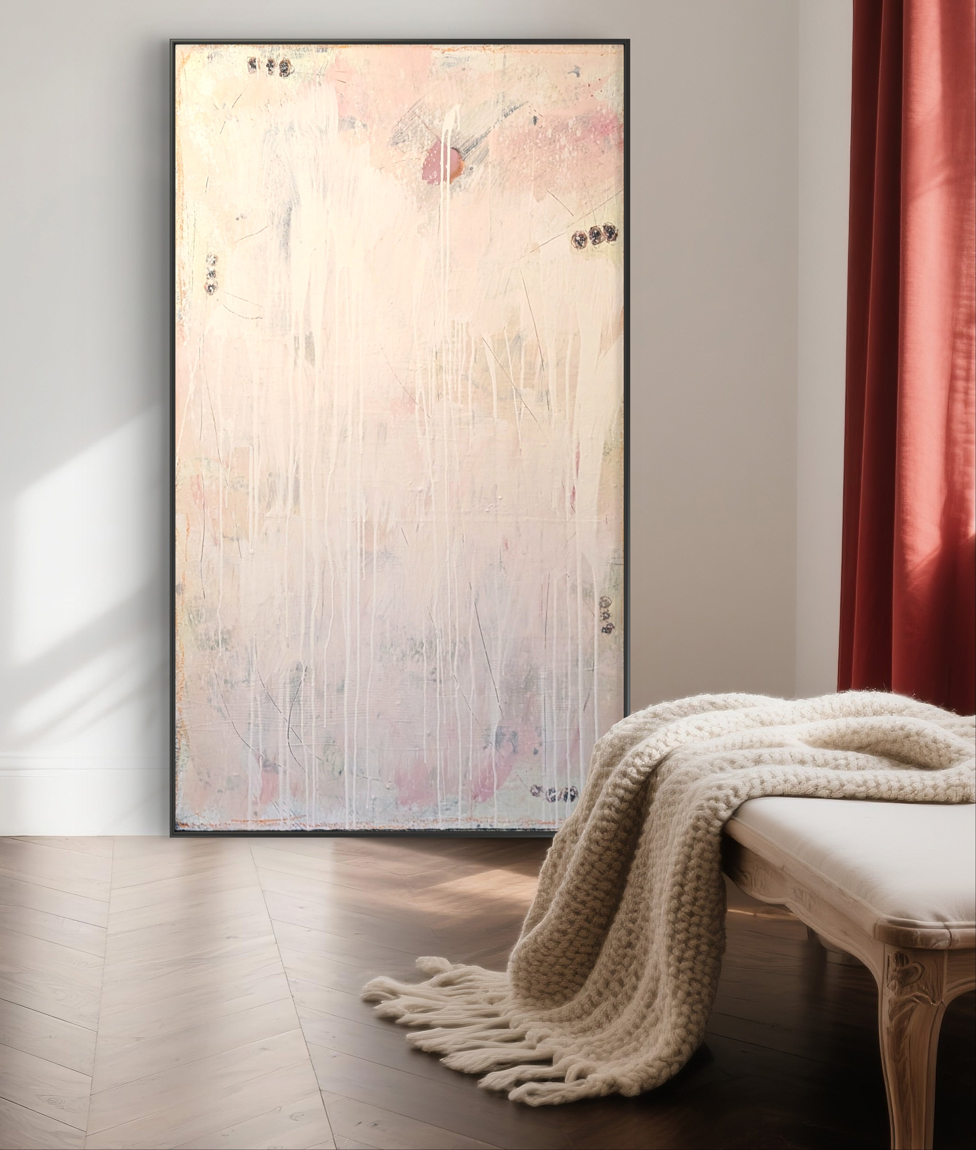 Das moderne abstrakte Gemälde "Eichhörnchentanz" von Conny Wachsmann, Artist, in sanften Pastellfarben mit weißen Tropfen steht als stilvolle Wanddeko neben einem Fenster mit roten Vorhängen; davor eine cremefarbene Strickdecke auf Bank.